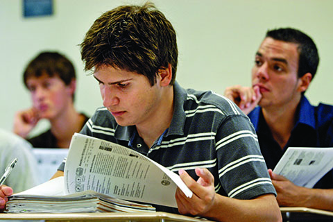Student reading an article in a classroom